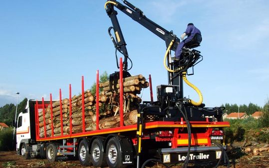 Operador de grúa colocando de madera en camión